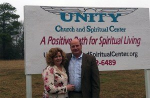 Rev Warren and Rev Francie of Unity Church standing by a temporary sign on the new property.
